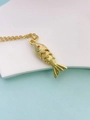 Macro view of gold fish pendant with realistic scales and a red gemstone eye detail - Bright Gold Style
