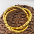 Dettaglio macro del bracciale a serpente Tubogas dorato con trama a spirale flessibile - Oro