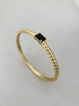 Dettaglio del bracciale ritorto placcato oro 18K con uno zircone nero rettangolare al centro - Stile Zircone a Costine / Nero