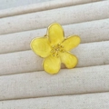Macro shot of camellia ring showing yellow enamel marble texture and golden flower petals - Yellow