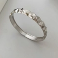 Detalle de brazalete plateado con textura geométrica y superficie facetada pulida - Brazalete Clou de Paris / Plateado (Estilo A)