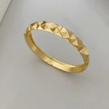 Detalle de brazalete de metal dorado con facetas geométricas y acabado pulido brillante - Brazalete Clou de Paris / Dorado (Estilo A)