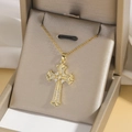 Detailansicht der goldenen Kreuzkette mit Zirkonia auf Seidenhintergrund - Stil G