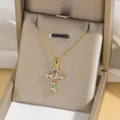 Detailaufnahme des vergoldeten Kreuzanhängers mit bunten Zirkoniasteinen in Schmuckbox - Stil F