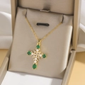 Elegant gold cross necklace with green stones and pearls displayed in a luxury gift box - Gold
