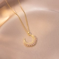 Detailed close-up of crescent moon necklace with pink and clear crystals on pink silk fabric - Pink and White Zirconia Crescent Style (X4193) / Gold