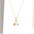 Gros plan du pendentif cerise dorée avec cristaux étincelants et détail feuille marquise - X4552