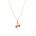 Detailopname van een gouden kersenhanger met rode hartvormige stenen aan een fijne ketting - X4548