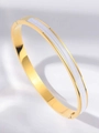 Detailed macro view of a gold-plated stainless steel bangle with white enamel inlay - White