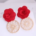 Detailed close-up of red fabric camellia earrings with gold wire-wrapped circles - Red