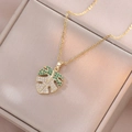 Detail of Monstera leaf pendant necklace featuring green gems and white diamonds - Gold Monstera Leaf Necklace