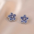 Detailaufnahme von Herzblumen-Ohrsteckern mit blauem Zirkon auf Champagnerseide - Blaue Blumenohrringe (E0192)