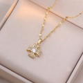 Collana a croce dorata con zircone centrale e cristalli in una scatola per gioielli beige - Stile Fiore in Zirconia Oro (X2379)