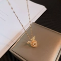 Collier cœur doré avec ailes d'ange et cristaux sur une boîte à bijoux de luxe - Or