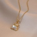 Gouden beer ketting met parelmoer hanger en strikje op zachte satijnen stof - Beer Ketting / Goud