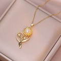 Vue détaillée d'un pendentif cœur tournesol doré avec cristaux sur fond champagne - X1166-tournesol