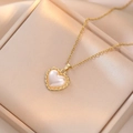 Elegante collana con ciondolo a cuore in perla dorata su una scatola per gioielli - Oro Cuore