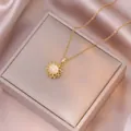 Gros plan d'un pendentif tournesol rotatif avec pierre œil-de-chat sur chaîne dorée - Collier Fleur en Œil de Chat (X1030)
