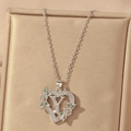 Macro detail of silver heart necklace with letter Y, zircons, and green gems decoration - Hollow Heart Letter Y Necklace / Silver