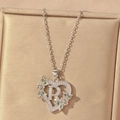 Detailed view of silver heart necklace with letter R, green gemstone flower and white zircons - Hollow Heart Letter R Necklace / Silver