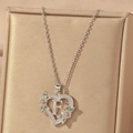 Detail of silver heart necklace with letter F, green stones and flower accents - Hollow Heart Letter F Necklace / Silver