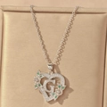 Macro detail of silver heart necklace with letter G and green gemstone in a jewelry box - Hollow Heart Letter G Necklace / Silver