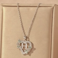 Detail of silver heart pendant with letter H, green zircon, and floral accents - Hollow Heart Letter H Necklace / Silver