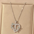 Macro view of heart-shaped letter L pendant with zircon flowers on champagne velvet - Hollow Heart Letter I Necklace / Silver