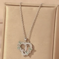 Detailed macro view of heart pendant with letter J and green stones on a silver chain - Hollow Heart Letter J Necklace / Silver