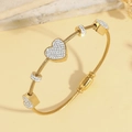 Dettaglio del bracciale a cavo dorato con ciondoli a cuore e cristalli scintillanti - Stile Oro (TT1005)
