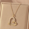 Elegant gold hollow heart pendant necklace with white crystals on a jewelry box - Heart-Shaped Pendant (X0802 Gold--1) / Gold