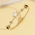 Bracciale in cavo d'oro con ciondoli a stella e perline di cristallo su sfondo neutro - Stile Ciondolo Stella a Cinque Punte / Stile Oro (TT1001)