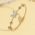 Dettaglio di un bracciale a cavo dorato con farfalle di cristallo e cursori pavé - Stile Oro (TT1003)