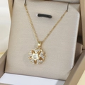 Halskette aus Titanstahl mit Schneeflocken-Anhänger und Zirkon auf Champagner-Seidenhintergrund - Goldene Blumenhalskette
