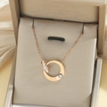 Elegante roségoldene Doppelring Halskette mit Zirkonia Besatz auf einer Schmuckschatulle - Roségold Doppelring Stil (T0104)