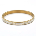 Vista detallada del brazalete de acero dorado con esmalte blanco y diseño de líneas geométricas - Dorado Blanco