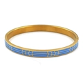 Detalle macro del esmalte azul cielo en el brazalete geométrico de acero dorado - Oro Azul