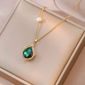 Elegant gold necklace with emerald teardrop pendant and pearl detail in jewelry box - Emerald Teardrop Necklace (X3504)