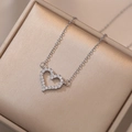 Close-up of hollow heart pendant with white zircons on champagne silk lining - Silver (X1965 Heart Necklace With Pendant)
