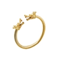 Detalle de cabezas de dragón talladas y textura de cable trenzado en el brazalete dorado - Estilo Dorado 2
