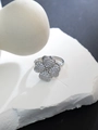 Macro shot of silver four-leaf clover ring with sparkling zircon inlays on stone base - Full Zirconia Heart Clover Style (JZ269) / Silver