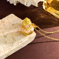Elegant gold hollow gourd necklace with pink enamel details on a stone surface - Antique Gold Pink Hulu (XL4371)