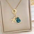 Gouden reishalsketting met gedetailleerde vliegtuighanger en blauwgroene kofferbedel - Vliegtuig Bagage Ketting Goud (XL4552)