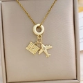 Gold travel plane necklace with suitcase charm and white zircon on a jewelry box - Gold