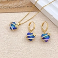 Three-piece jewelry set with blue gradient heart pendants and gold flower accents - Necklace and Earring Set / Gold / Light Blue