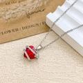 Silver-toned heart necklace featuring a red crystal pendant with a delicate floral accent - Necklace / Silver / Red