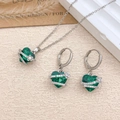 Green heart crystal jewelry set with necklace and earrings on a cream textured surface - Necklace and Earring Set / Silver / Green