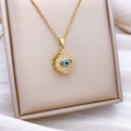 Rotating golden evil eye necklace with blue stones and turquoise inlay details - Gold