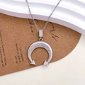 Silver crescent moon necklace with sparkling crystals on a minimalist display - Full Pave Arc Moon Design (XL3319) / Silver