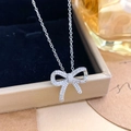 Elegant silver bow pendant necklace with sparkling cubic zirconia on a jewelry box - Full Zirconia Bow Style (XL2111) / Silver